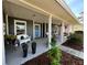 Charming front porch with neutral colors, plenty of plants, and seating area at 121 Belmont Dr, Winter Haven, FL 33884