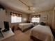 Cozy bedroom features two twin beds, wood paneling, and a ceiling fan at 2055 S Floral Ave # 73, Bartow, FL 33830