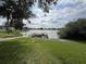 Scenic lake view featuring a private dock and lush green surroundings on a partly cloudy day at 2055 S Floral Ave # 73, Bartow, FL 33830