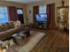 Living room with a brown leather sofa, wood floors, and a large TV at 217 Bay E St, Davenport, FL 33837