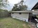 Side exterior view of the house featuring siding, a lawn, and a ladder at 3445 Avenue F Nw, Winter Haven, FL 33880