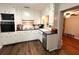 Galley-style kitchen featuring white cabinets, stainless steel appliances, and hardwood floors at 3445 Avenue F Nw, Winter Haven, FL 33881