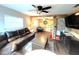 Cozy living room with leather sofa, ceiling fan, and view into the adjacent room at 3445 Avenue F Nw, Winter Haven, FL 33881