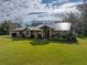 Brick house with metal roof, landscaping, and large yard at 3703 White Oak Ct, Lake Wales, FL 33898