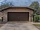 Attached two-car garage with a dark brown door at 3703 White Oak Ct, Lake Wales, FL 33898