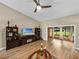 Bright living room featuring hardwood floors, a media console, and access to a sunroom and backyard at 3703 White Oak Ct, Lake Wales, FL 33898