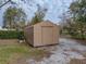 Tan storage shed with single door in backyard at 3703 White Oak Ct, Lake Wales, FL 33898