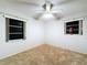 Clean bedroom featuring carpet flooring, ceiling fan and two windows at 41 Spring Ln, Haines City, FL 33844