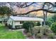 Side view of a charming home with lush landscaping, mature trees and a metal roof at 41 Spring Ln, Haines City, FL 33844