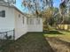 Exterior view of the home's backyard, complemented by lush greenery and a wooden fence at 4128 W Bella Vista St, Lakeland, FL 33810