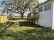 View of the home's backyard featuring a wooden deck and expansive green space at 4128 W Bella Vista St, Lakeland, FL 33810