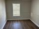 A clean, basic bedroom with wood-look floors, neutral wall colors, and a bright window at 4128 W Bella Vista St, Lakeland, FL 33810