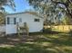 Rear exterior of a house with a fenced yard and a wooden staircase leading to a back entrance at 4128 W Bella Vista St, Lakeland, FL 33810