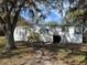 Well-maintained single-Gathering home with white siding, a small shed, and a lawn with large trees at 4128 W Bella Vista St, Lakeland, FL 33810