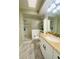 Well-lit bathroom with a vanity, tiled floor, and shower stall with glass blocks at 419 Broward Ter, Winter Haven, FL 33884