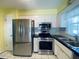 Kitchen with stainless steel appliances, white cabinets, and tile flooring at 419 Broward Ter, Winter Haven, FL 33884