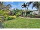 Beautifully landscaped backyard featuring a well-manicured lawn, brick pathway, and an array of tropical plants and trees at 4523 Hallamview Ln, Lakeland, FL 33813