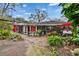 Spacious backyard featuring a brick patio, lush gardens, and the house exterior, offering a serene and inviting outdoor space at 4523 Hallamview Ln, Lakeland, FL 33813