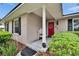 Charming front porch with a red door, brick facade, and tidy landscaping at 4523 Hallamview Ln, Lakeland, FL 33813