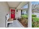 Inviting front porch with a bright red door, offering a warm welcome to this home at 4523 Hallamview Ln, Lakeland, FL 33813