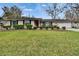 Charming one-story home with a manicured lawn, brick exterior, and a bright red front door at 4523 Hallamview Ln, Lakeland, FL 33813