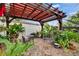 Cozy patio area featuring a wooden pergola, brick pavers, and an abundance of potted plants, creating a serene outdoor retreat at 4523 Hallamview Ln, Lakeland, FL 33813