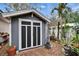 A charming shed with black and white doors, nestled in a landscaped backyard with beautiful flowers and palm trees at 4523 Hallamview Ln, Lakeland, FL 33813