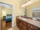 Bathroom with granite countertop, double sinks, and a view of the bedroom at 465 Rowland Ct, Bartow, FL 33830