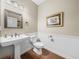 Elegant powder room with pedestal sink, wood floors and wainscoting at 465 Rowland Ct, Bartow, FL 33830