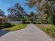 Brick driveway with landscaping and mature trees at 465 Rowland Ct, Bartow, FL 33830