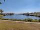 Peaceful lakefront view with grassy area and sidewalk at 465 Rowland Ct, Bartow, FL 33830