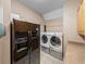 Laundry room with washer, dryer, refrigerator, and wooden cabinets at 465 Rowland Ct, Bartow, FL 33830