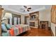 Bright main bedroom featuring hardwood floors, ceiling fan, fireplace, and French doors to the outdoor patio at 520 E Stanford St, Bartow, FL 33830