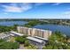 Scenic aerial view of a waterfront apartment complex surrounded by lush greenery at 700 Mirror Nw Ter # 403, Winter Haven, FL 33881