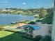 Waterfront view featuring pool, boat docks, and manicured lawn area with lush landscaping at 700 Mirror Nw Ter # 403, Winter Haven, FL 33881