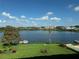 Waterfront view featuring a blue lake, clear sky, lush green lawn and landscaped grounds at 700 Mirror Nw Ter # 403, Winter Haven, FL 33881