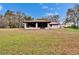 The rear exterior of the home showcases the screened-in sunroom set in a sprawling backyard at 7929 Chase Rd, Lakeland, FL 33810