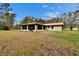 Wide backyard featuring the rear exterior of the home and the screened sunroom at 7929 Chase Rd, Lakeland, FL 33810