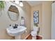 Charming powder room featuring a pedestal sink, modern fixtures, and tasteful floral decorations at 7929 Chase Rd, Lakeland, FL 33810