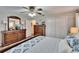 Comfortable bedroom featuring wood furniture, ceiling fan, a closet and stylish blue and white patterned bedding at 7929 Chase Rd, Lakeland, FL 33810