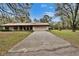 Inviting home with a long driveway, well-manicured lawn, and mature landscaping for a welcoming curb appeal at 7929 Chase Rd, Lakeland, FL 33810