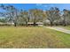 Expansive green lawn with mature trees leading to a single story residence at 7929 Chase Rd, Lakeland, FL 33810