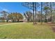 Serene view of a home surrounded by mature trees and a sprawling green lawn at 7929 Chase Rd, Lakeland, FL 33810