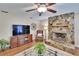 Cozy living room featuring a stone fireplace, hardwood floors, and comfortable armchair at 7929 Chase Rd, Lakeland, FL 33810