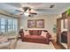 Cozy living room featuring a comfortable brown sofa, white shutters, and stylish decor at 7929 Chase Rd, Lakeland, FL 33810