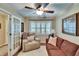 Bright living room with a beige recliner, brown sofa, shutters, and a ceiling fan at 7929 Chase Rd, Lakeland, FL 33810