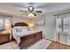 Bright main bedroom with a wooden bed frame, shutters, and decorative pillows at 7929 Chase Rd, Lakeland, FL 33810