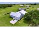 Aerial view of a well-maintained home with a metal roof, showcasing the large lot and surrounding lush greenery at 1040 Timbers Dr, Fort Meade, FL 33841