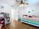 Bright bedroom features a ceiling fan, wood-look floors, and a cute desk at 1040 Timbers Dr, Fort Meade, FL 33841