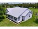 Exterior aerial view of a modern farmhouse with a metal roof surrounded by lush landscaping and green lawns at 1040 Timbers Dr, Fort Meade, FL 33841